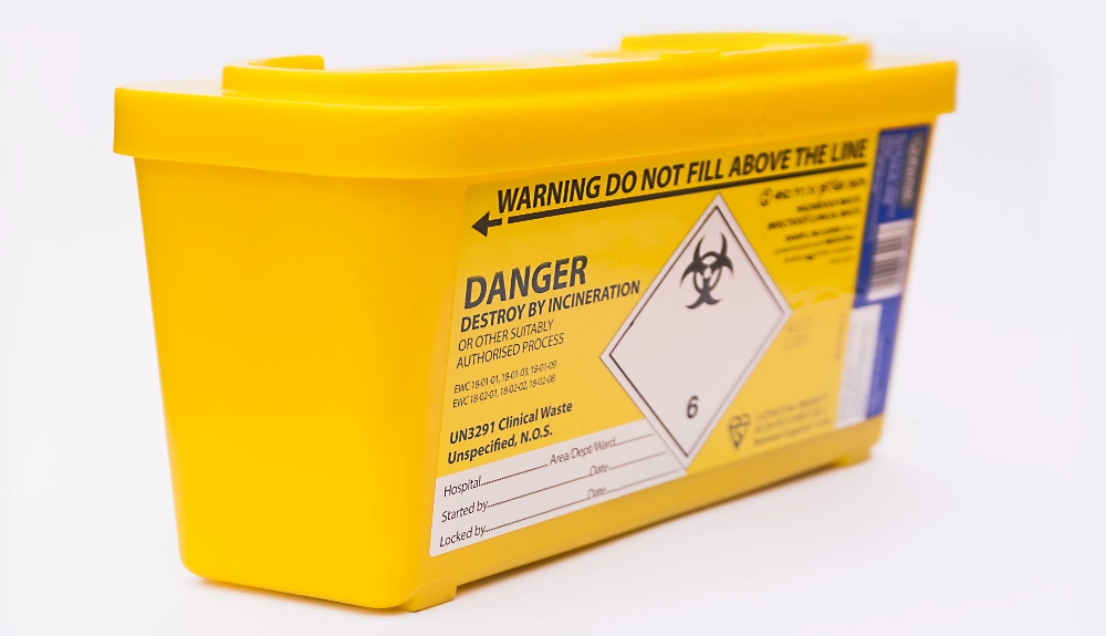 Yellow NWR Hygiene clinical waste needles and sharps bin with the word ‘DANGER’ in bold.