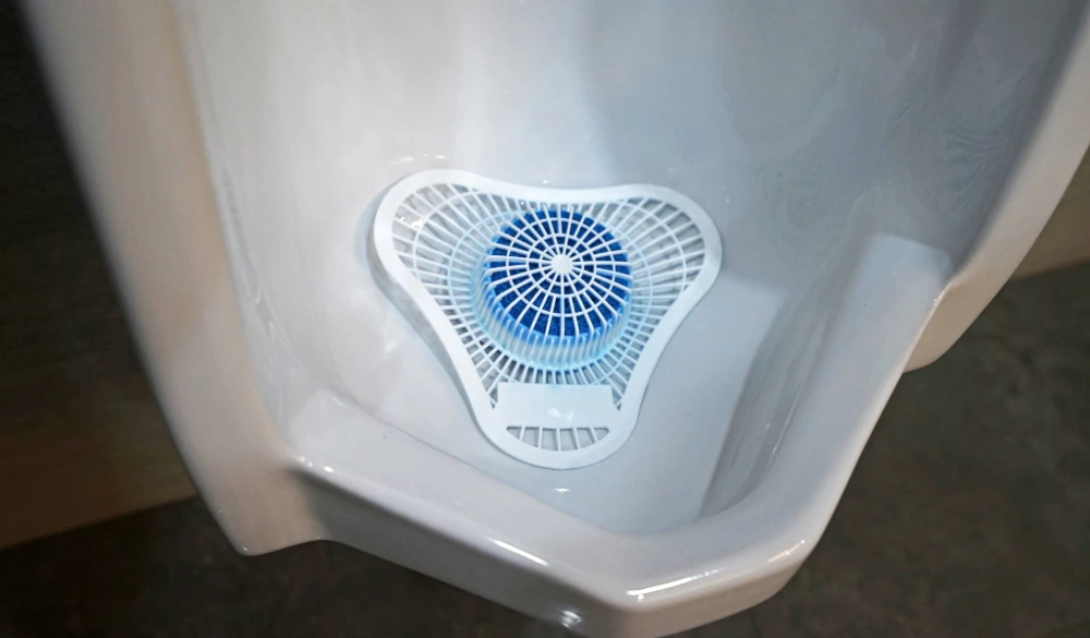 Close up blue urinal screen in a urinal example.